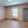 large room with bright window and wall mounted ac unit