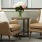 two chairs and a table with flowers in the corner of a room