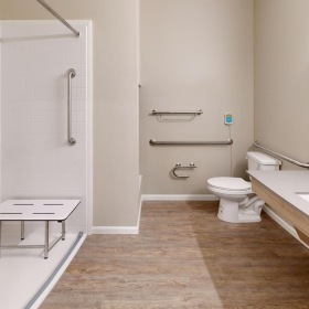 Spacious bathrooms with everything you need handicap features in well lit bathroom with walk-in shower